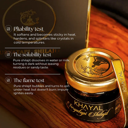 Khayal Shilajit jar with a gold tool on a wooden surface, featuring test descriptions.